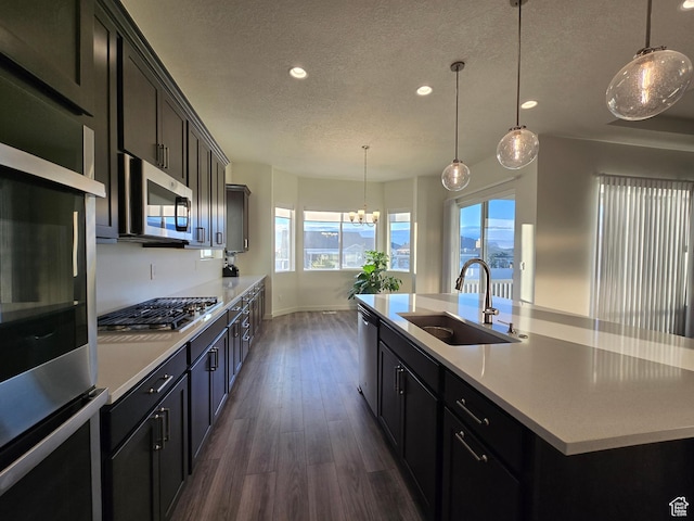697 N 3275 W, Layton, UT 84041 - kitchen featuring a textured ceiling, recessed lighting, appliances with stainless steel finishes, dark wood-style floors, and an island with sink