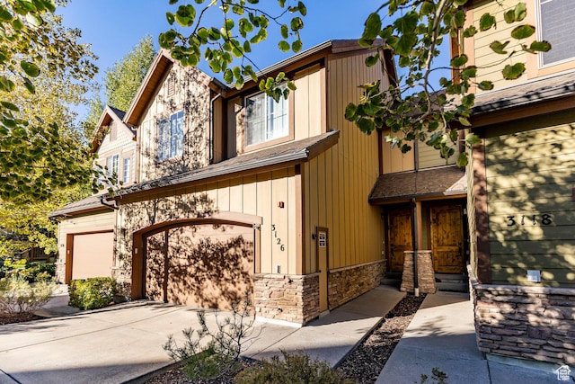 3126 Lower Saddleback Rd, Park City, UT 84098 - view of front facade with board and batten siding, an attached garage, stone siding, and concrete driveway