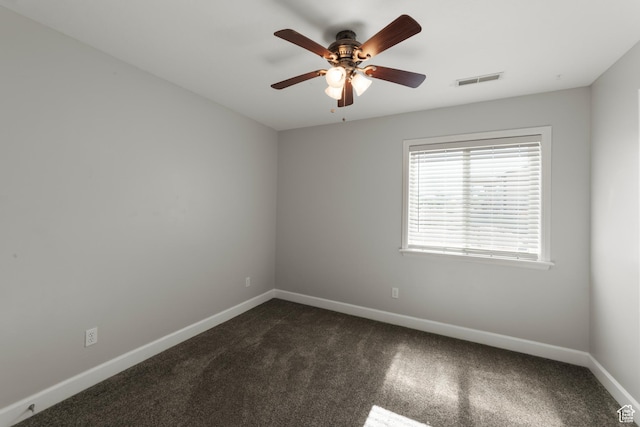 spare room with baseboards, ceiling fan, and dark colored carpet