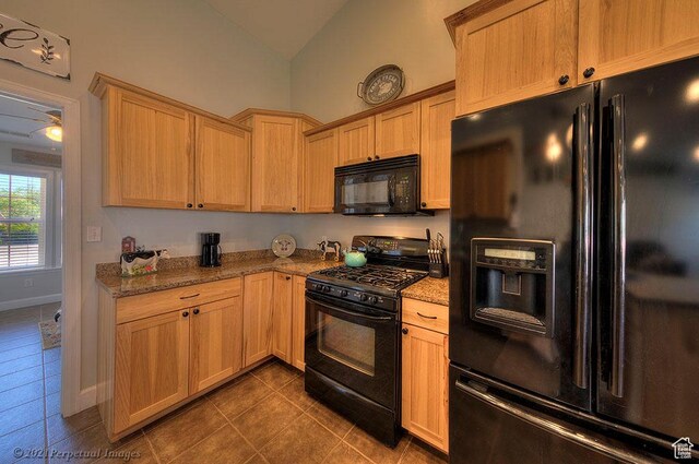 2304 Spanish Valley Dr, Moab, UT 84532 - kitchen with black appliances, dark tile patterned flooring, light stone counters, vaulted ceiling, and baseboards