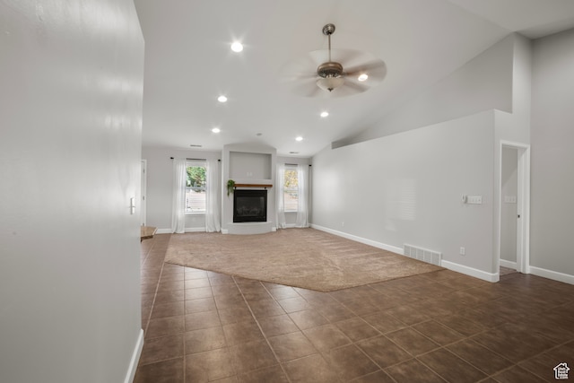 unfurnished living room featuring a ceiling fan, dark tile patterned floors, recessed lighting, vaulted ceiling, and baseboards