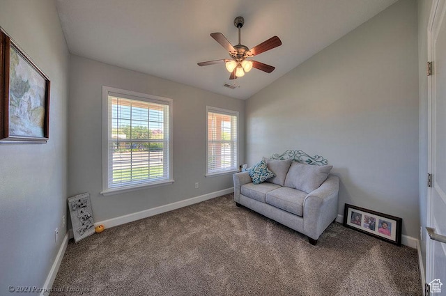 living area featuring carpet flooring, vaulted ceiling, baseboards, and ceiling fan