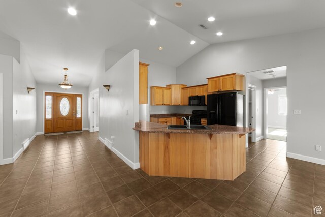 2304 Spanish Valley Dr, Moab, UT 84532 - kitchen with black appliances, dark tile patterned flooring, a peninsula, a kitchen breakfast bar, and baseboards