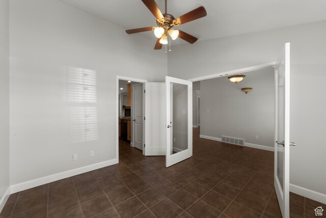 2304 Spanish Valley Dr, Moab, UT 84532 - unfurnished bedroom with french doors, baseboards, dark tile patterned flooring, and ceiling fan
