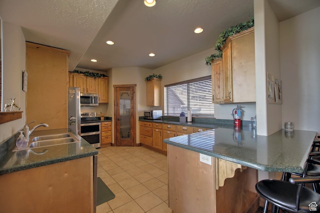 21 Gentle Ben Cir, Fish Haven, ID 83287 - kitchen featuring sink, light tile patterned flooring, kitchen peninsula, stainless steel appliances, and a breakfast bar area