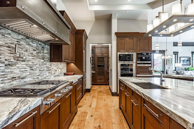 1159 Snow Berry St, Park City, UT 84098 - kitchen with light wood finished floors, a sink, extractor fan, tasteful backsplash, and appliances with stainless steel finishes