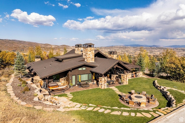 1159 Snow Berry St, Park City, UT 84098 - rear view of house with a chimney, a patio area, a fire pit, and a mountain view