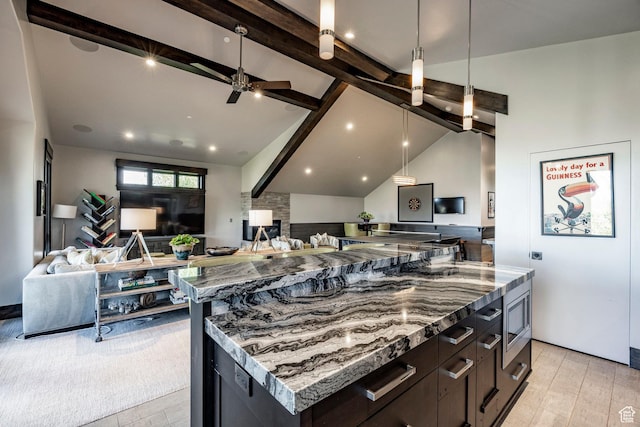 1159 Snow Berry St, Park City, UT 84098 - kitchen featuring dark stone counters, lofted ceiling with beams, open floor plan, stainless steel microwave, and ceiling fan