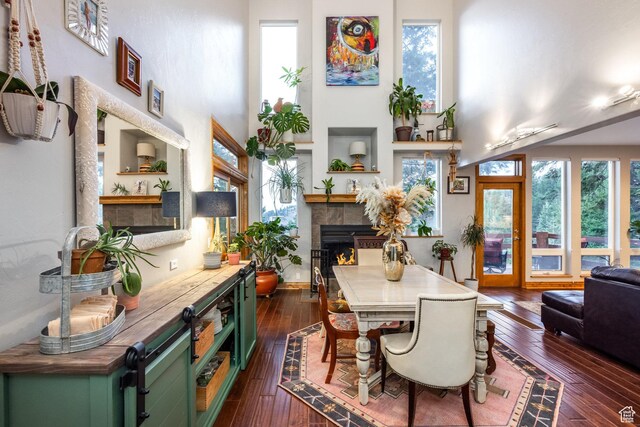 105 Paradise Rd, Summit Park, UT 84098 - dining area with a tiled fireplace, dark wood-style flooring, a towering ceiling, and healthy amount of natural light