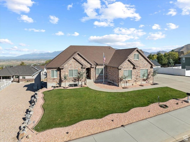51 E Magellan Ln, Elk Ridge, UT 84651 - view of front of property featuring stone siding, a mountain view, central air condition unit, and roof with shingles