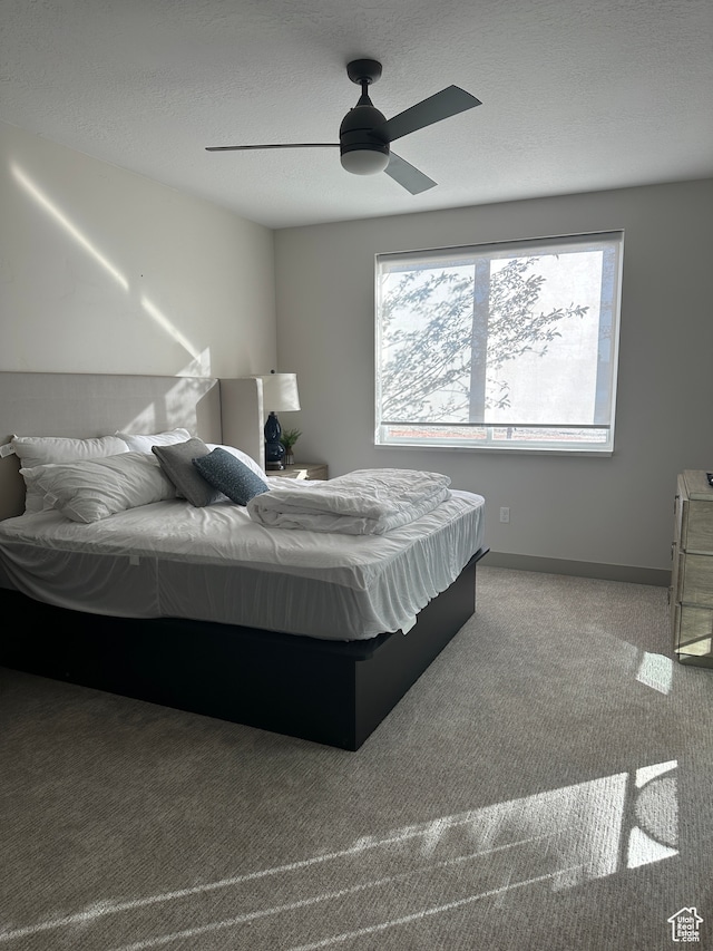 bedroom featuring carpet floors, a textured ceiling, and ceiling fan