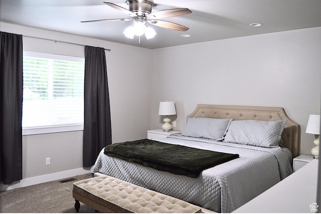 carpeted bedroom with ceiling fan and baseboards