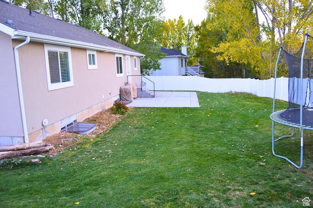 view of yard featuring a fenced backyard, a patio, and a trampoline