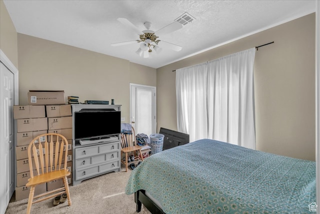 bedroom featuring a textured ceiling, carpet floors, and ceiling fan