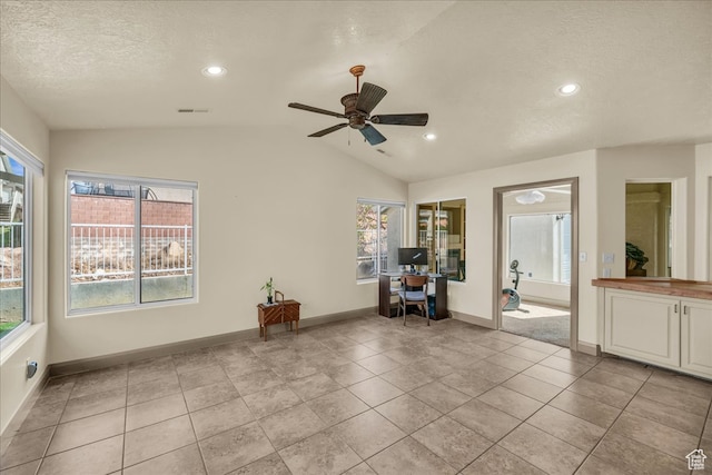 interior space featuring a wealth of natural light, lofted ceiling, light tile patterned flooring, and ceiling fan