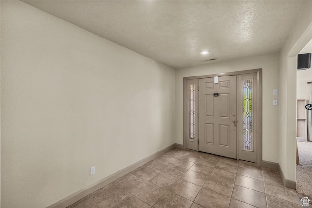 entryway featuring a textured ceiling and light tile patterned floors