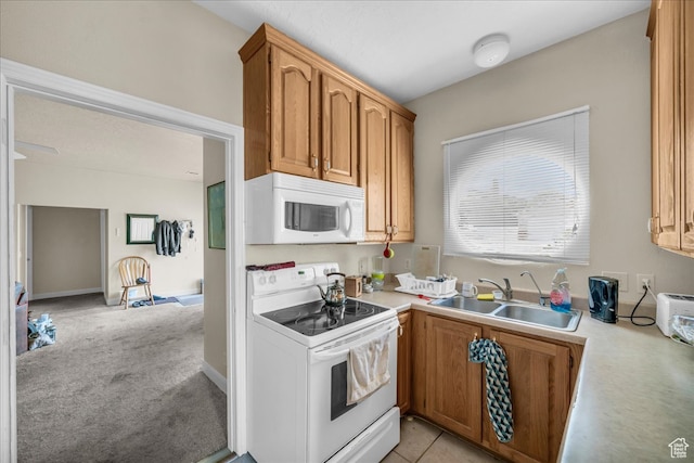 kitchen with sink, light carpet, and white appliances