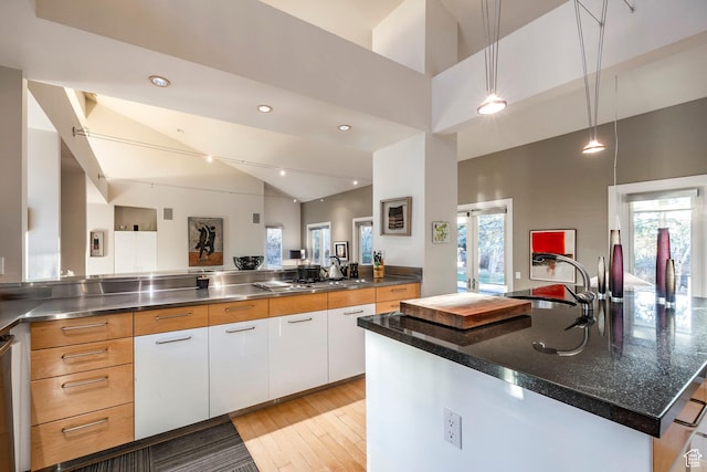 671 N Freeze Creek Cir, Emigration Canyon, UT 84108 - kitchen with stainless steel counters, a sink, lofted ceiling, white cabinetry, and light wood finished floors