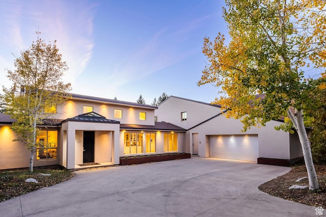 671 N Freeze Creek Cir, Emigration Canyon, UT 84108 - view of front of house with stucco siding, driveway, a standing seam roof, a garage, and metal roof