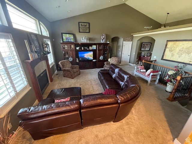 5020 W Haven Rd, West Haven, UT 84401 - carpeted living area featuring arched walkways, high vaulted ceiling, a glass covered fireplace, and baseboards