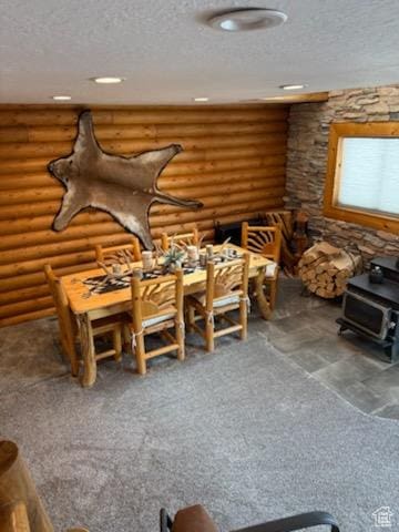 misc room featuring a textured ceiling, a wood stove, log walls, carpet, and recessed lighting