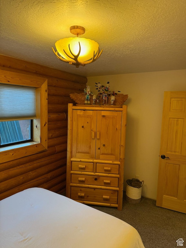 bedroom featuring a textured ceiling, log walls, and carpet