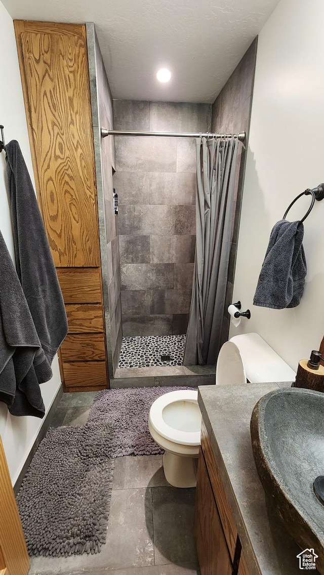 bathroom featuring toilet, a shower stall, and vanity