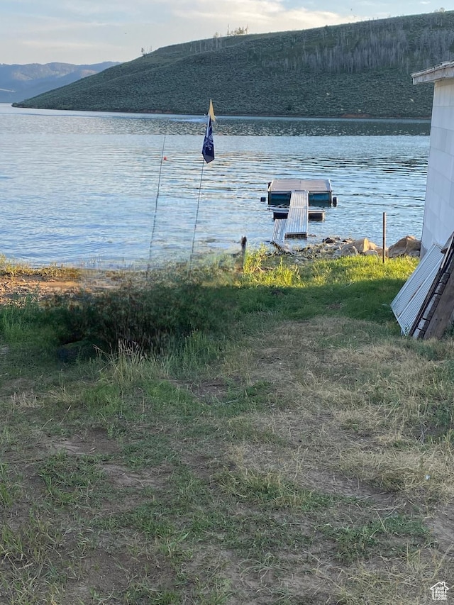 property view of water with a floating dock and a mountain view