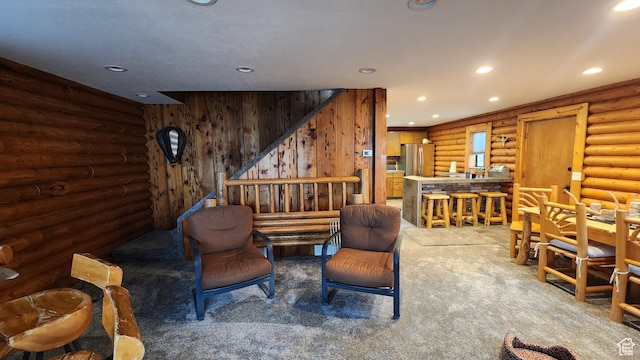living area featuring carpet floors, recessed lighting, rustic walls, and stairway