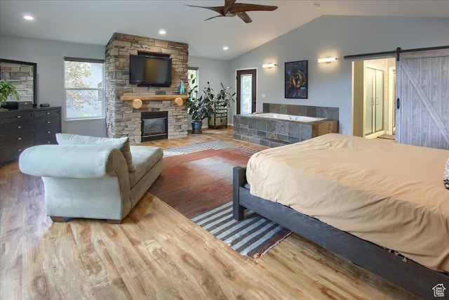 3937 N Patio Springs Dr, Eden, UT 84310 - bedroom featuring lofted ceiling, a stone fireplace, wood-type flooring, a barn door, and ceiling fan