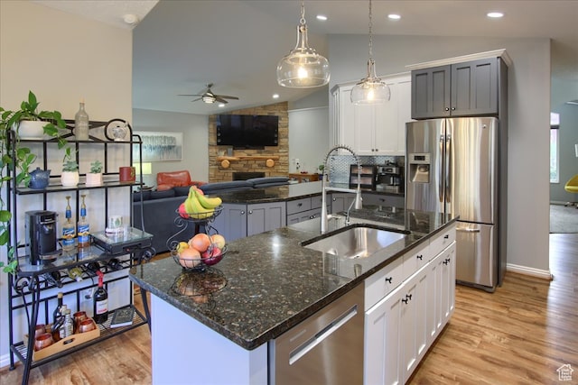 3937 N Patio Springs Dr, Eden, UT 84310 - kitchen with stainless steel appliances, a kitchen island with sink, lofted ceiling, and white cabinets