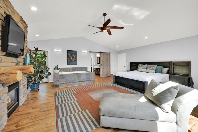 3937 N Patio Springs Dr, Eden, UT 84310 - bedroom featuring a barn door, vaulted ceiling, light wood-style floors, a fireplace, and recessed lighting