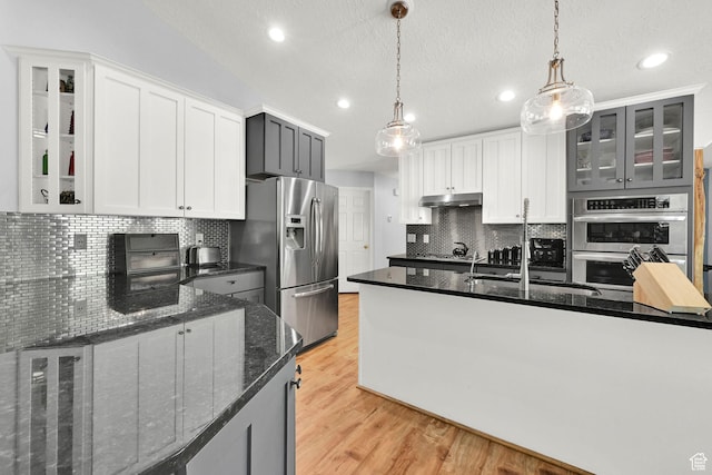 3937 N Patio Springs Dr, Eden, UT 84310 - kitchen featuring appliances with stainless steel finishes, backsplash, light wood-style floors, a sink, and recessed lighting