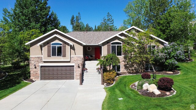 3937 N Patio Springs Dr, Eden, UT 84310 - view of front of house featuring stone siding, stucco siding, concrete driveway, a garage, and a front lawn