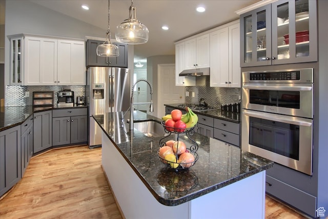 3937 N Patio Springs Dr, Eden, UT 84310 - kitchen featuring an island with sink, appliances with stainless steel finishes, white cabinetry, pendant lighting, and sink