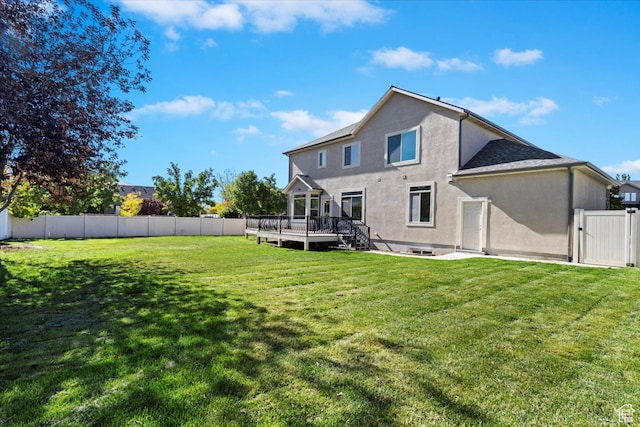 back of house with a yard and a deck