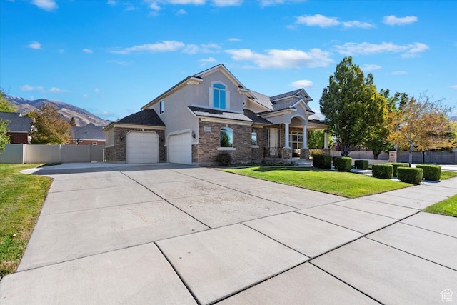 view of front of house with a front yard, a garage, and a mountain view