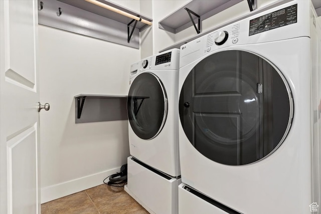 clothes washing area with washer and clothes dryer and light tile patterned floors