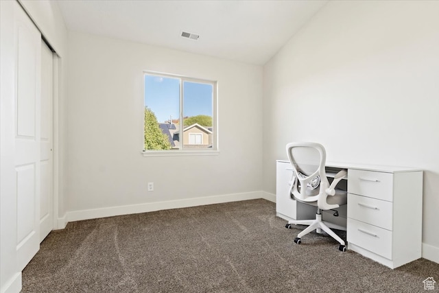 unfurnished office with lofted ceiling and dark colored carpet