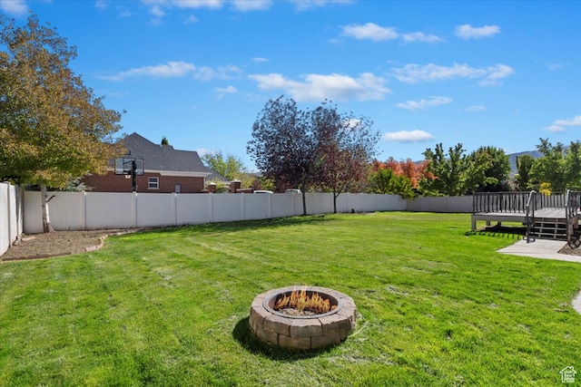 view of yard with a deck and a fire pit