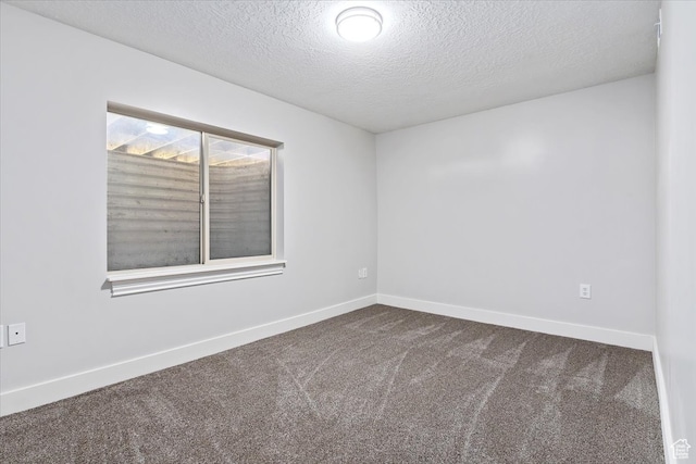 empty room with carpet flooring and a textured ceiling