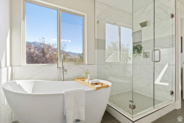 bathroom with tile walls, shower with separate bathtub, and a mountain view