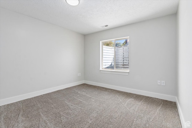 empty room with a textured ceiling and carpet floors