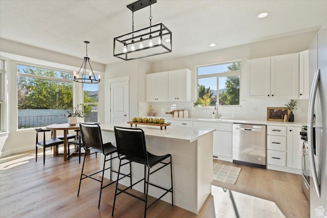 13133 S Crystal Springs Dr, Draper, UT 84020 - kitchen with stainless steel appliances, a sink, backsplash, light countertops, and a kitchen island
