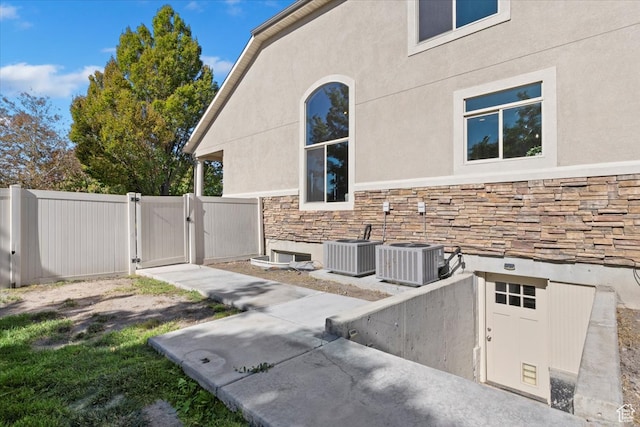 view of side of home with central AC