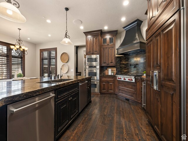 kitchen with decorative backsplash, decorative light fixtures, stainless steel appliances, and custom exhaust hood