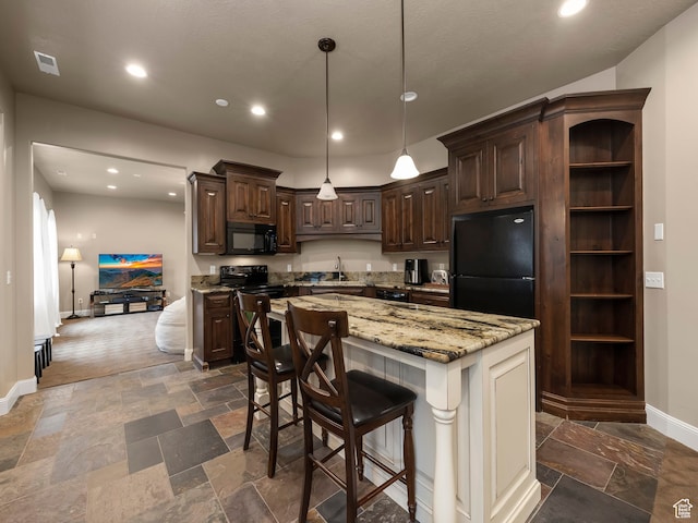 kitchen featuring a kitchen island, black appliances, a kitchen bar, sink, and dark brown cabinetry