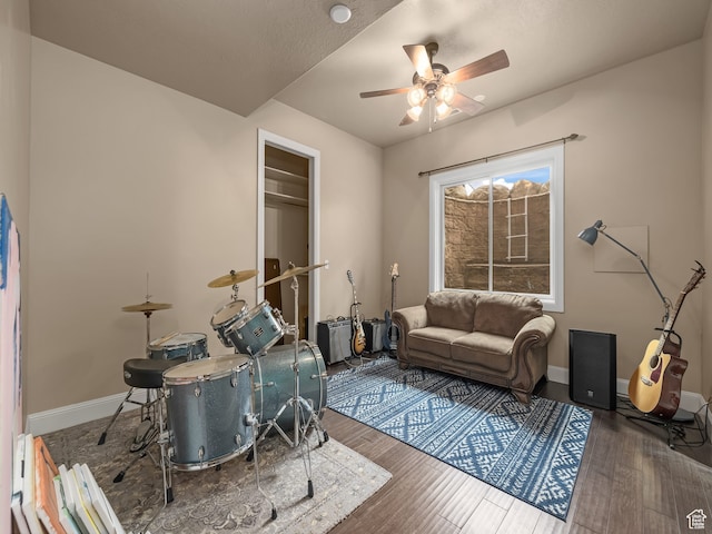 living room with ceiling fan and dark wood-type flooring