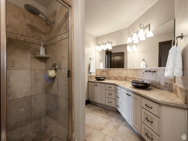 bathroom featuring decorative backsplash, a shower with door, vanity, and tile patterned flooring