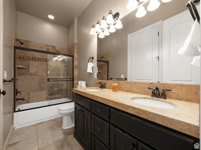full bathroom featuring toilet, bath / shower combo with glass door, tile patterned floors, and vanity